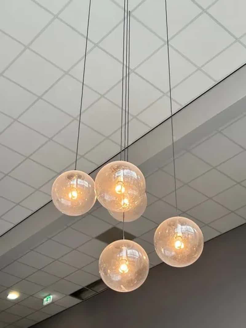 #9 - Globe Pendant Lights Hanging Over Every Dining Table (Image Credits: Pexels)
