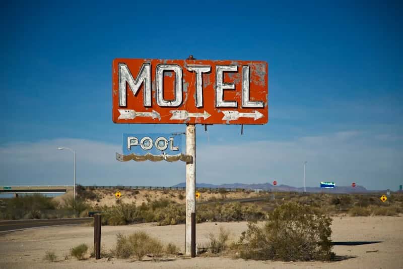 Pulling into a motel lit up by a glowing neon sign (Image Credits: Unsplash)
