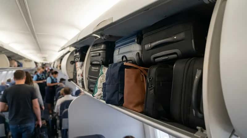 #11 - Stuffing a Personal Item Into the Overhead Bin (Image Credits: Gemini)