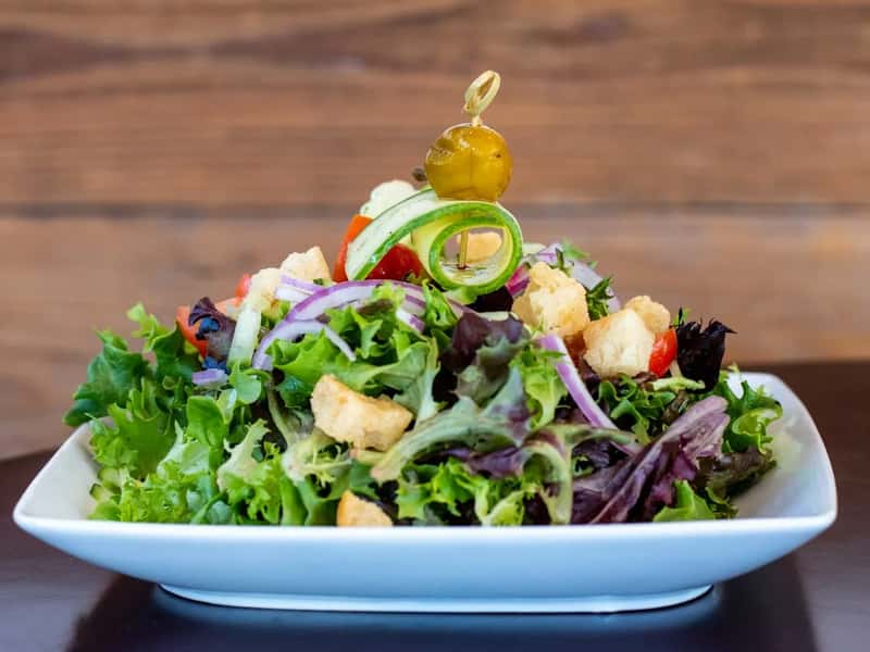 Salads with the dressing already tossed (Image Credits: Unsplash)