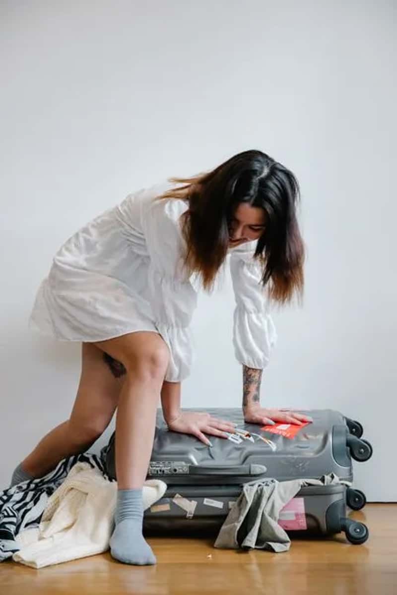 4. Zipping a suitcase completely full with zero spare room (Image Credits: Pexels)