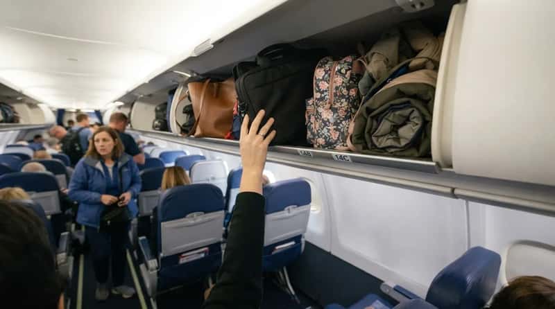 #8 - Stuffing Your Personal Item Overhead Instead of Under the Seat (Image Credits: Gemini)