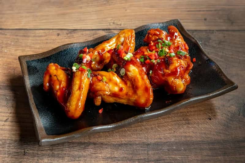 Spicy wings, curry bowls, and hot sauce loaded dishes (Image Credits: Unsplash)