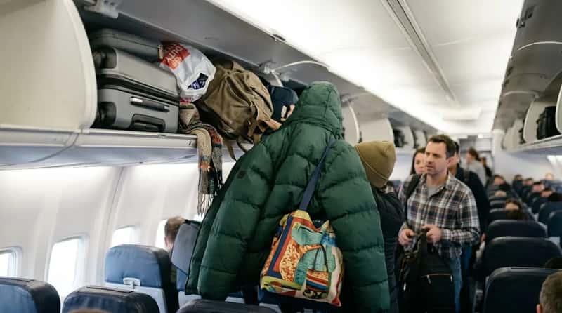 #9 - Treating the Overhead Bin Like a Personal Closet (Image Credits: Gemini)