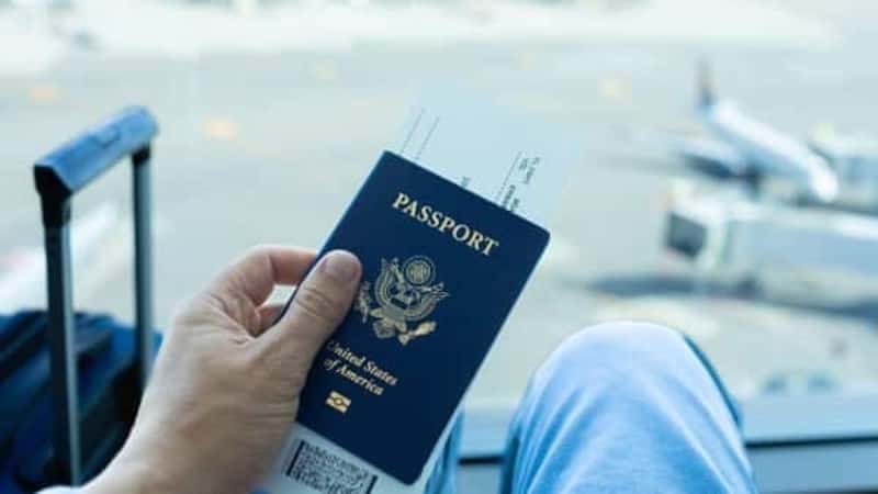 Traveler at the airport with USA passport in hand