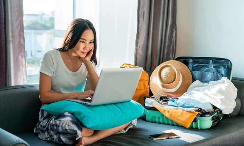 Happy female using computer to planning travel trip