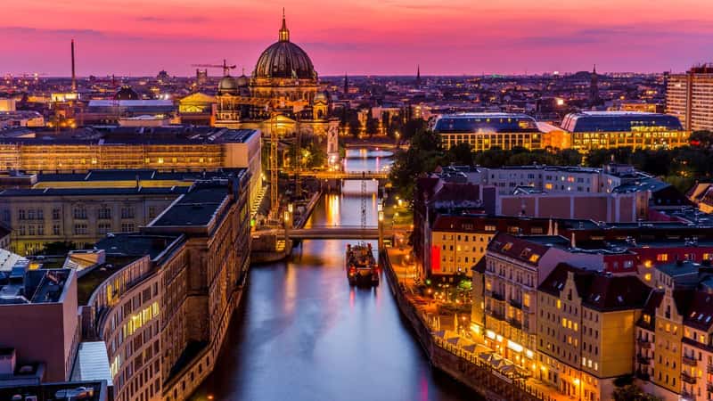 Panoromic aerial view of Berlin skyline with famous TV tower and Spree river in beautiful post sunset twilight during blue hour at dusk with dramatic colorful clouds , central Berlin Mitte, Germany