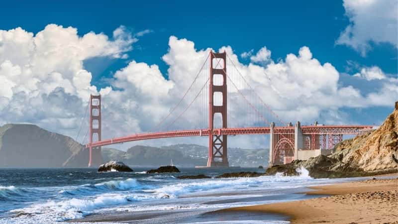 A view of the iconic red bridge in San Francisco, known as the Golden Gate Bridge. The image captures the bridge's distinctive red hue and spans the strait connecting San Francisco Bay to the Pacific Ocean. The architectural elements of the suspension bridge, including its towers and cables, are clearly visible.