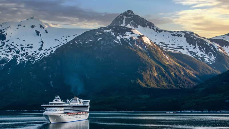 Evening sky over the Alaskan mountain range, boats on the Inside Passage. Alaska Cruise. Cruise ship.