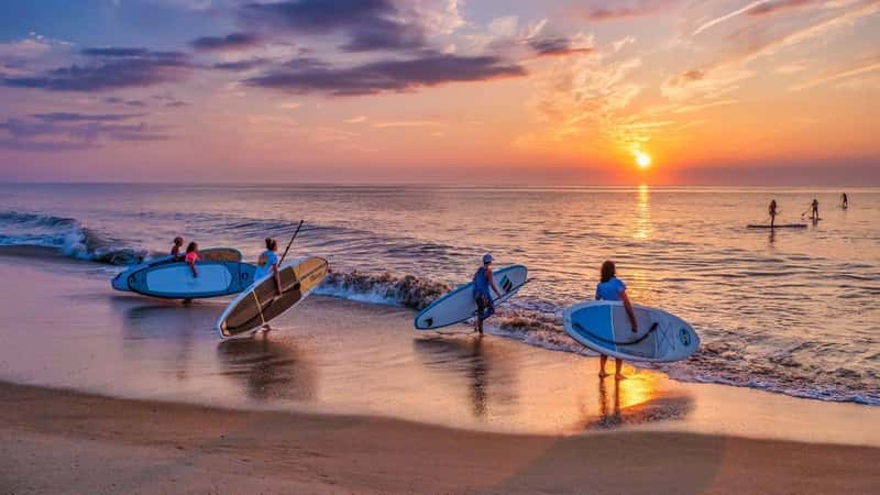 : A group of young women who most mornings during the summer months take their paddle boards out at sunrise to paddle several miles up or down the coast.