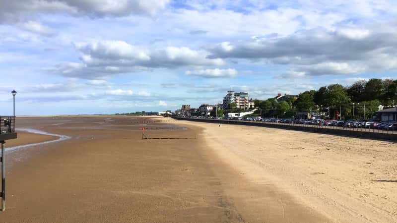 Cleethorpes beach, with the town in the background, presents a wide sandy shoreline on the left, contrasting with the urban landscape of the town on the right.