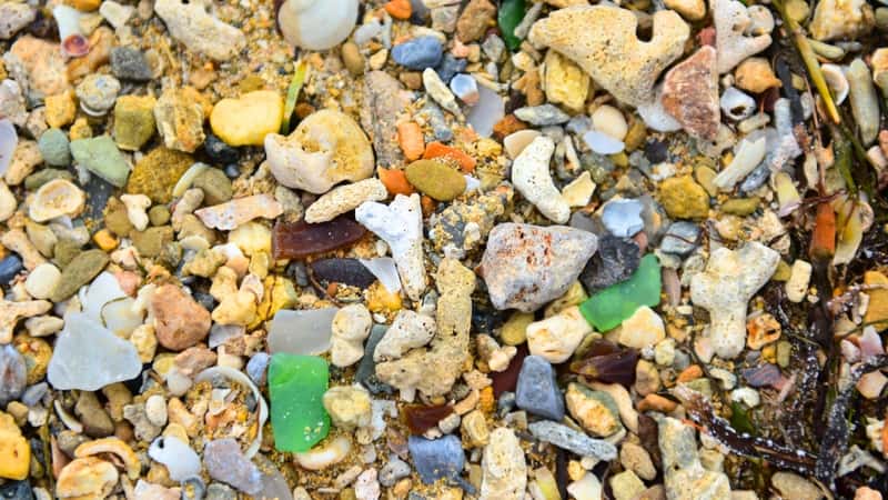Sea Glass Beach in Okinawa, Japan, is renowned for its colorful glass bits scattered throughout the sand. The beach has a unique appearance due to the abundance of sea glass, which comes in various sizes and colors.