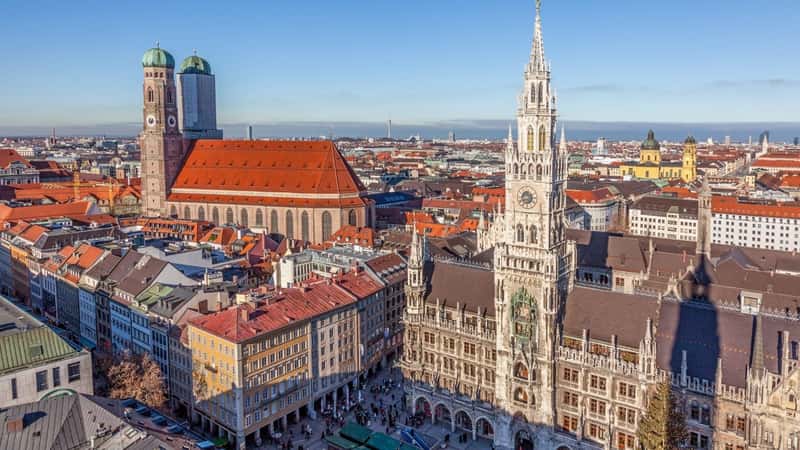 A cityscape view of Munich, Germany, featuring Marienplatz and the town hall. The image captures the urban environment with surrounding buildings and streets. Marienplatz, a central square, is dominated by the town hall's architecture.