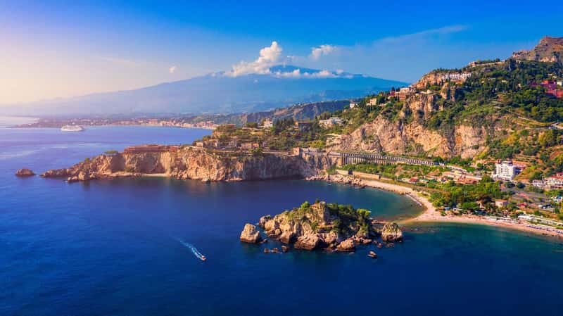 Taormina is a city on the island of Sicily, Italy. Mount Etna over Taormina cityscape, Messina, Sicily. View of Taormina located in Metropolitan City of Messina, on east coast of Sicily island, Italy.