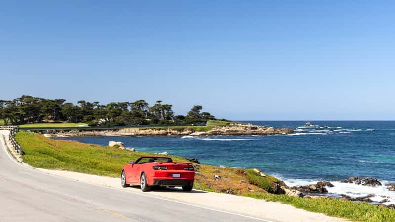 Discover the breathtaking coastal beauty of the scenic 17-Mile Drive in California, showcasing the vast expanse of the majestic ocean under clear skies.