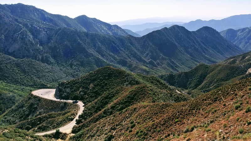 The image captures Angeles Crest Highway winding through the rugged terrain of Angeles National Forest, California.