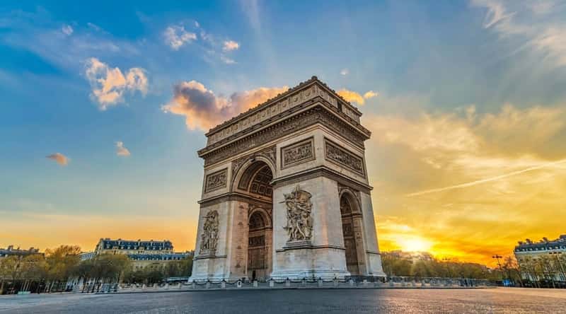 A photograph capturing the Parisian city skyline during sunset, featuring prominent landmarks such as the Arc de Triomphe.