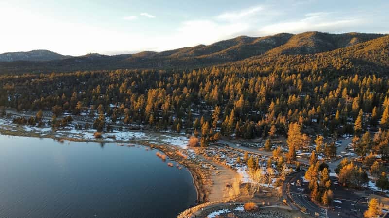 The image showcases San Bernardino National Forest at Big Bear Lake, featuring dense pine forests and a tranquil lake.