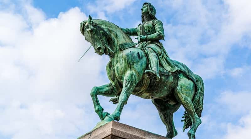 Close up of the Joan of Arc statue photographed from below with a cloudy sky background in Orleans France.