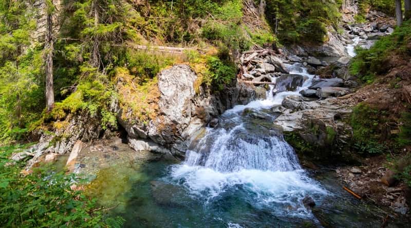 Les Gorges de la Diosaz, a stunning gorge located in Chamonix, France. The narrow gorge is carved by the Diosaz River. The river, with its crystal-clear waters, flows through the heart of the gorge, cascading over smooth rocks and forming small waterfalls.