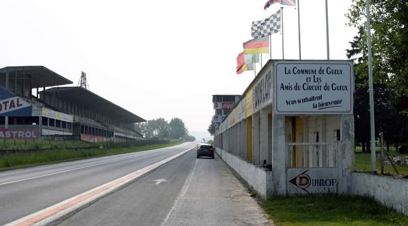 The historic Reims-Gueux circuit photographed on a cloudy day. A deserted road with a single car.