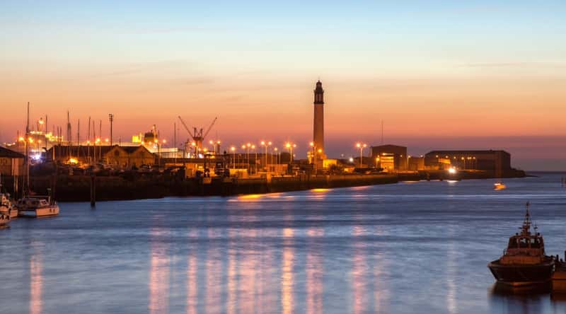 Port du Bassin du Commerce in Dunkirk France, at sunset, with the lights reflecting off the water.