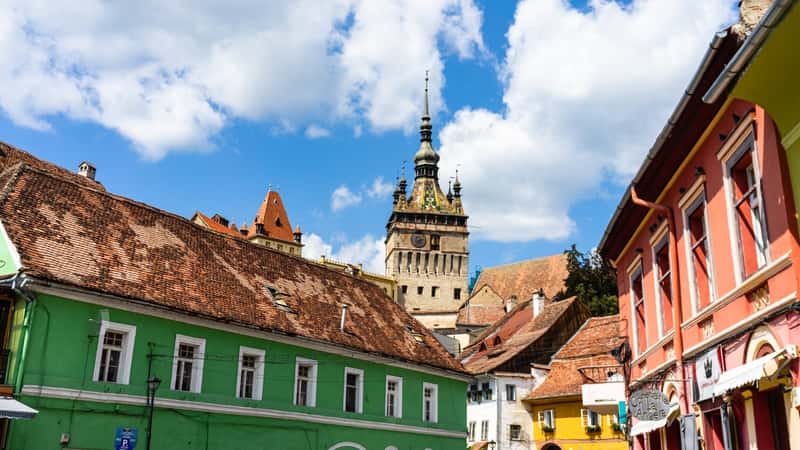 The image showcases the medieval fortified citadel of Sighisoara city, prominently featuring the famous Clock Tower. The citadel's architecture reflects its historical significance and defensive design typical of medieval fortifications.