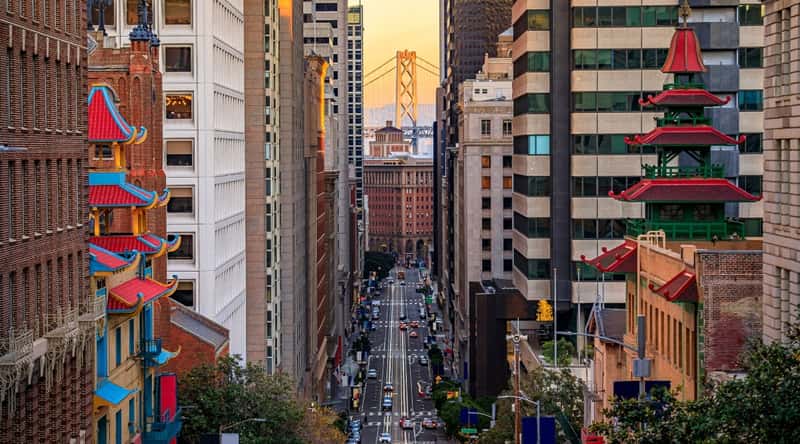 Street view of Chinatown near the financial district in downtown San Francisco. There are several buildings with red tops, that are reminiscent of their home country.