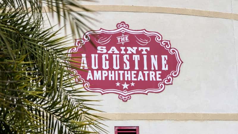 The image features a close-up view of a sign displaying "The St. Augustine Amphitheater."