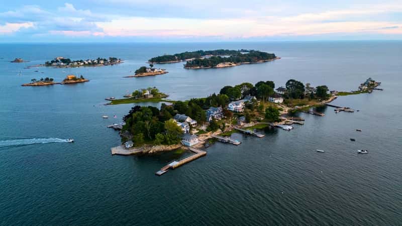 The image presents an aerial view of the Thimble Islands in Branford, Connecticut. The islands are scattered across the water, creating a unique and picturesque coastal landscape. 