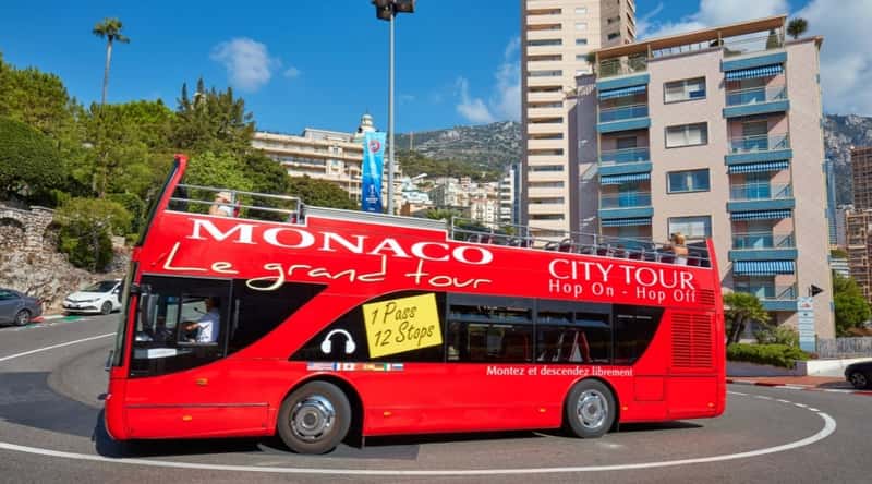 A vibrant image captures the scene of a tourist bus navigating the enchanting streets of Monaco, France. The bus, adorned with colorful graphics and the allure of exploration, winds its way through the principality's scenic landscapes. Tourists aboard the bus enjoy panoramic views of Monaco's iconic landmarks.