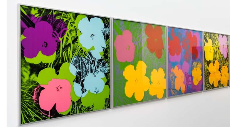 Close up display of Andy Warhol paintings of flowers in a contemporary style.