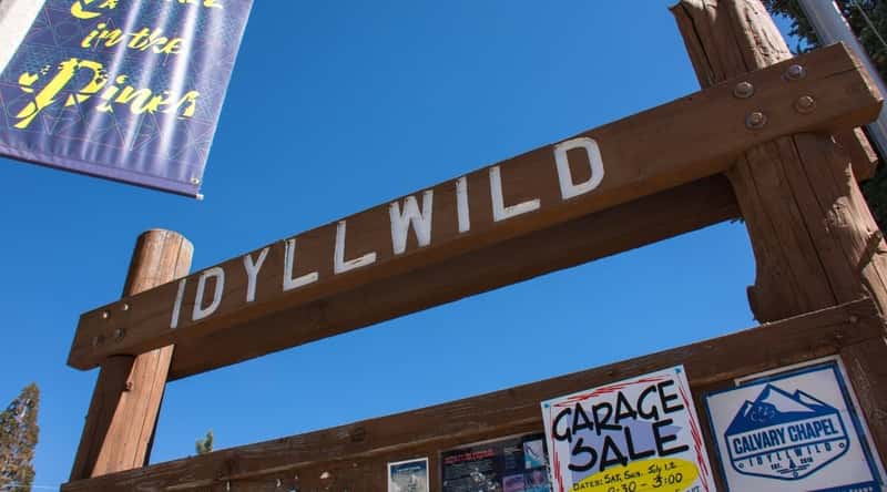 A close-up photograph capturing an inscription sign in Idyllwild. The image showcases a wooden sign with the inscription 'Idyllwild' in a straightforward manner. The sign features a basic design, displaying the town's name with no distinctive embellishments.