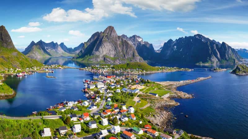 Reine, Lofoten, Norway. The village of Reine under a sunny, blue sky, with the typical rorbu houses. View from the top