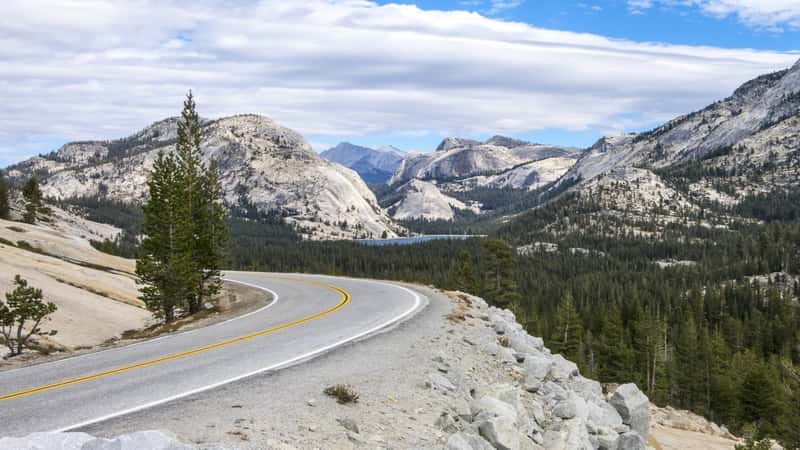 This image showcases Tioga Pass, a high mountain pass in the Sierra Nevada mountains of California. The pass is located within Yosemite National Park. In the image, Tioga Pass is depicted with its winding road and surrounding rocky landscape.