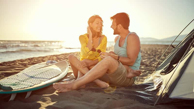 Happy couple on vacation camping on the beach.