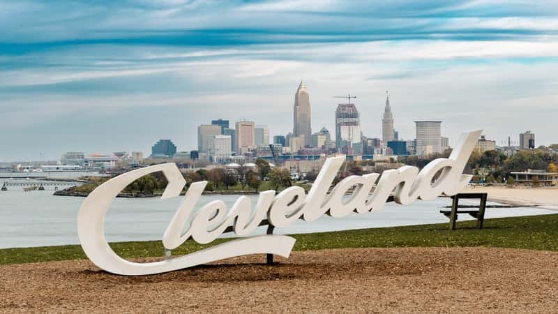 Cleveland Script sign at Edgewater park with city skyline in the background.