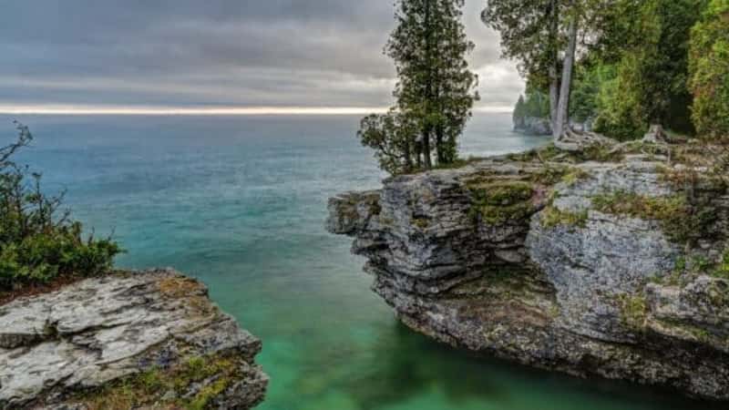 The rocky coast of Door County, Wisconsin's Cave Point displays beautiful colors in the light of a stormy sunrise.