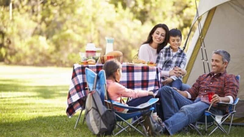 Family Enjoying Camping Holiday In Countryside