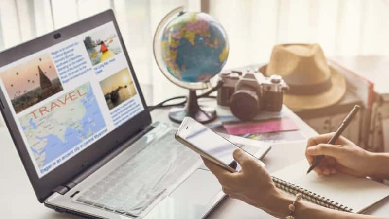 Young woman planning vacation trip and searching information or booking an hotel on a smart phone and laptop, Travel plan concept