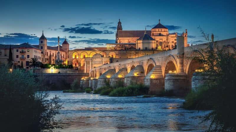 Cordoba Skyline at sunrise with Cathedral, Roman Bridge and San Rafael triumphal monument - Cordoba, Andalusia, Spain