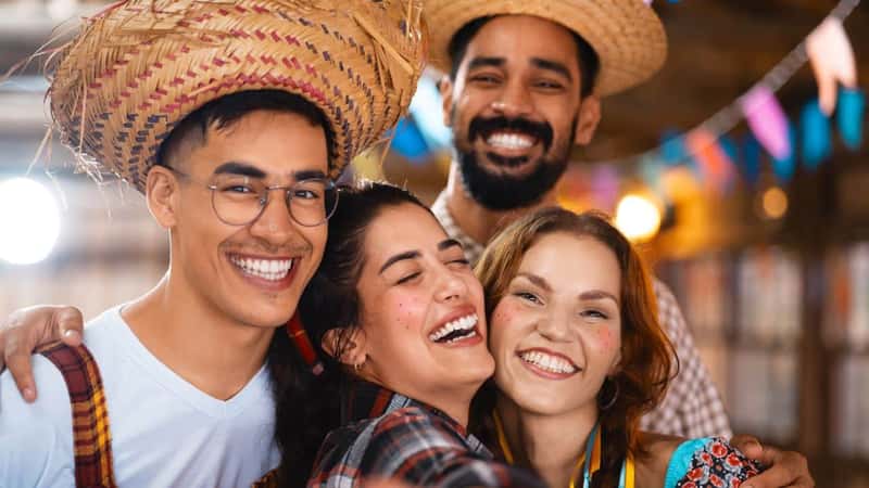 Friends sharing laughter and capturing memories at a festive Brazilian Junina celebration. Group of jovial companions in traditional attire taking a joyous selfie