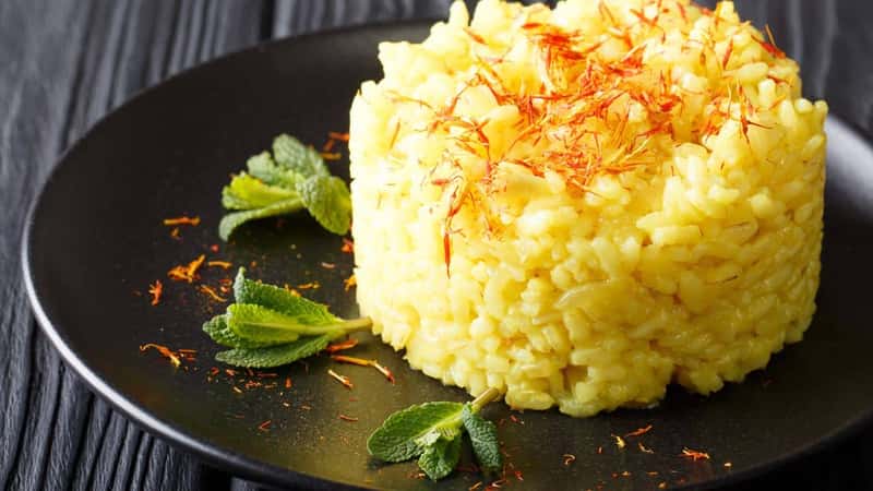 Vegetarian Italian food: risotto with saffron and mint (Risotto alla milanese) closeup on a plate. horizontal