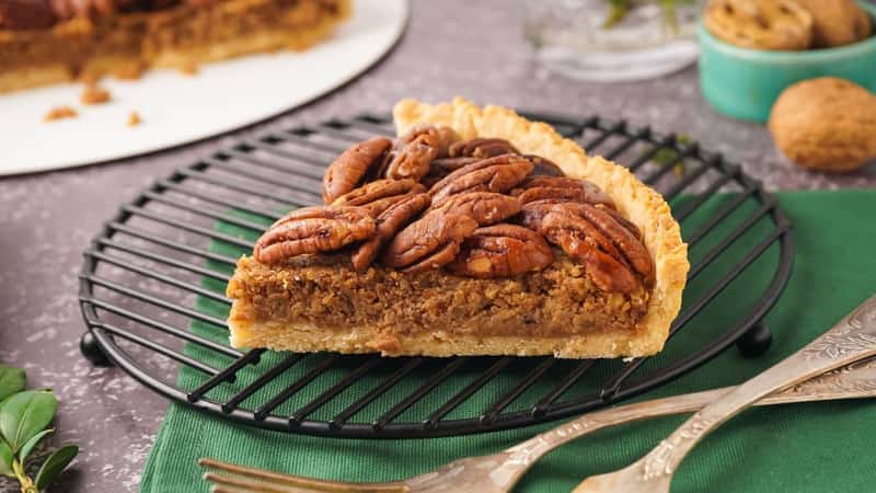 Grid with piece of tasty pecan pie on grey background