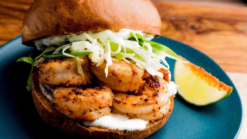 Fried shrimp Sandwich. Po boy sandwich. Fish and Chips. Classic Cajun cuisine: fried shrimp sandwich bun with onions, lettuce, tomato, mayo, salt and pepper. Classic New Orleans sandwich favorite.