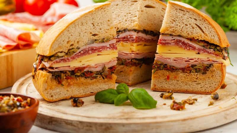 Muffuletta. Sandwich with cheese, ham and olive paste. A traditional recipe in New Orleans. Front view.