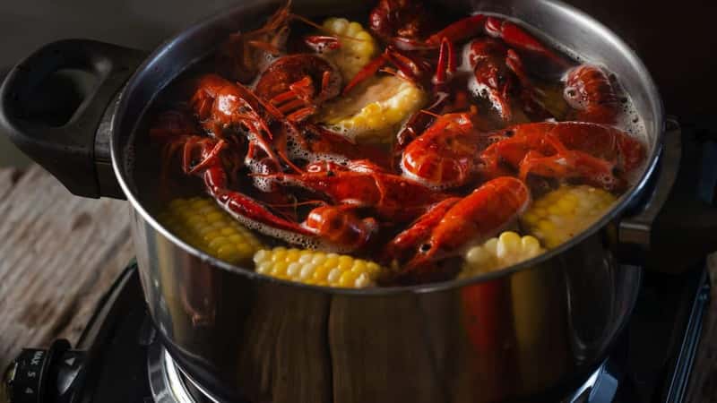 A saucepan in which crayfish, corn and potatoes are boiled Cooking process