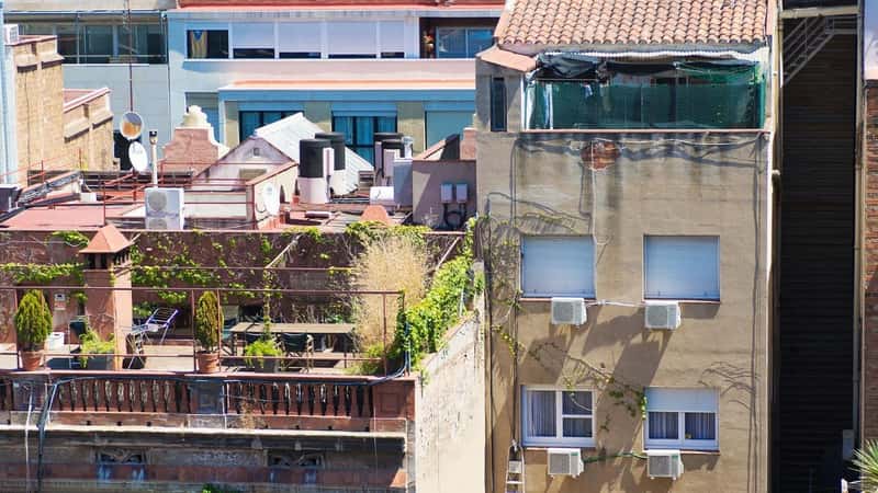 Rooftop view on Barcelona city, cityscape and streets, buildings and roofs. Residential buildings, dense urban development. Catalonia, Spain