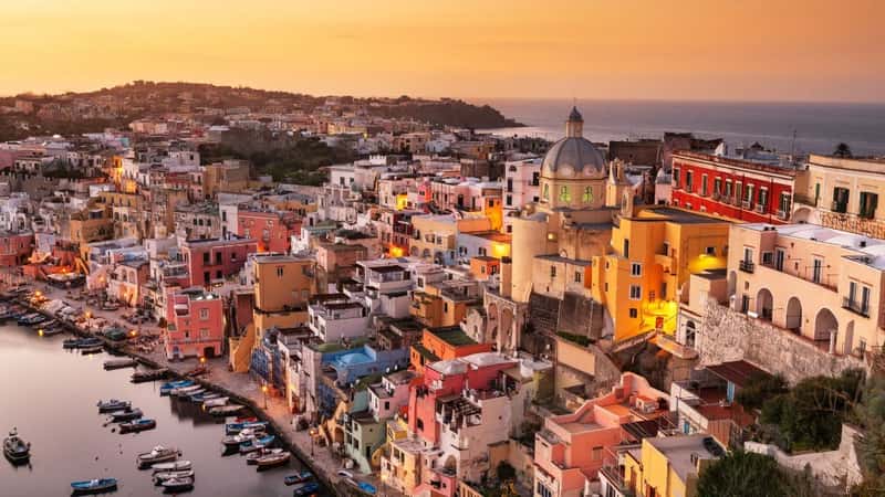 Procida, Italy old town skyline in the Mediterranean Sea during dusk.
