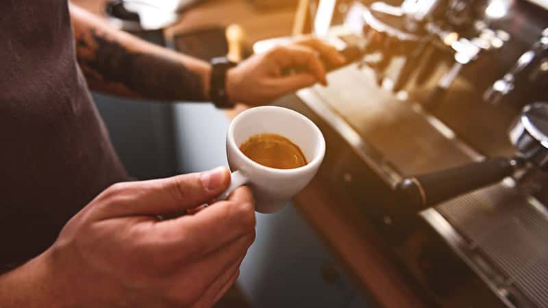 cup with hot cappuccino in man hands